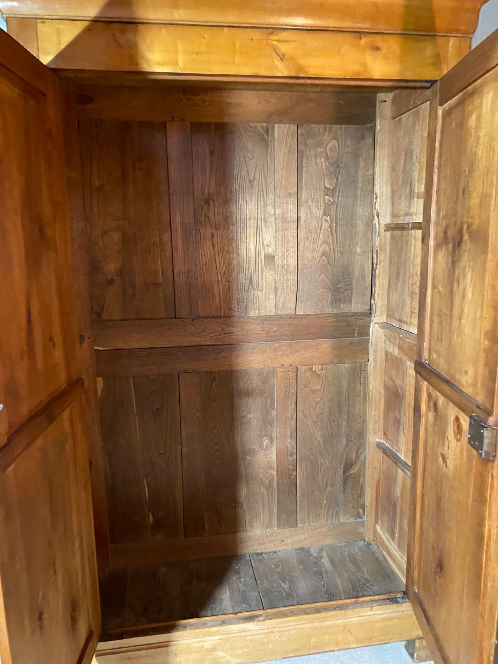 A tall 19th-century cherry wood armoire featuring double panelled doors, decorative iron keyplates, and a projecting upper cornice. View XV