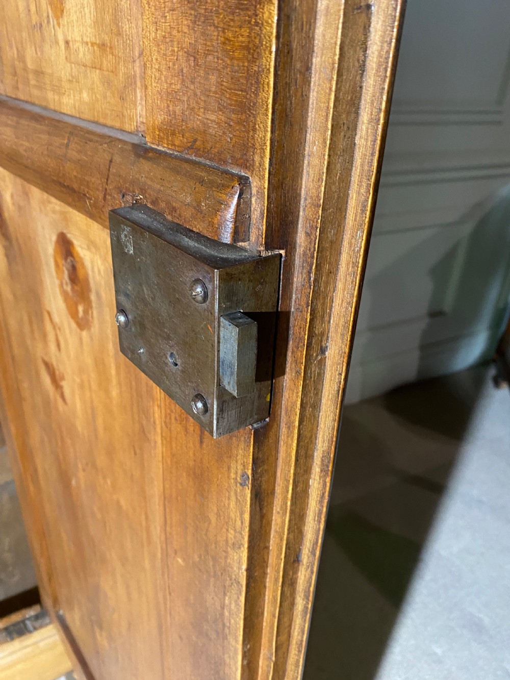 A tall 19th-century cherry wood armoire featuring double panelled doors, decorative iron keyplates, and a projecting upper cornice. View XIX