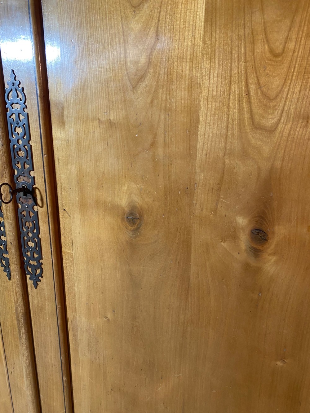 A tall 19th-century cherry wood armoire featuring double panelled doors, decorative iron keyplates, and a projecting upper cornice. View XXIII