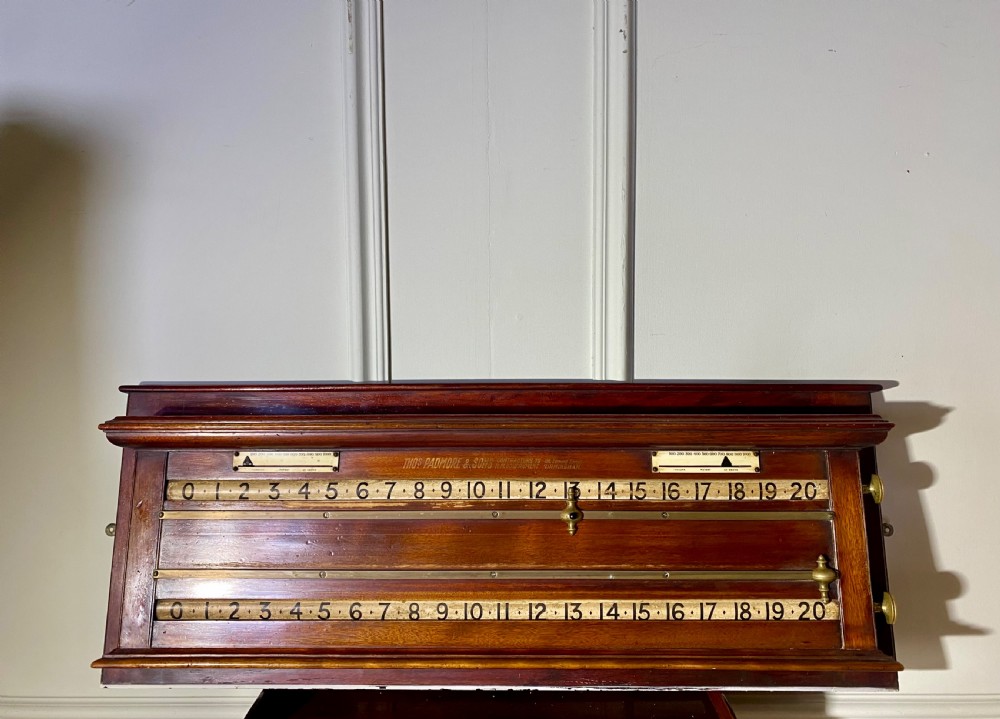 An antique Victorian mahogany and brass snooker scoreboard featuring sliding pointer markers and numbered tracks.