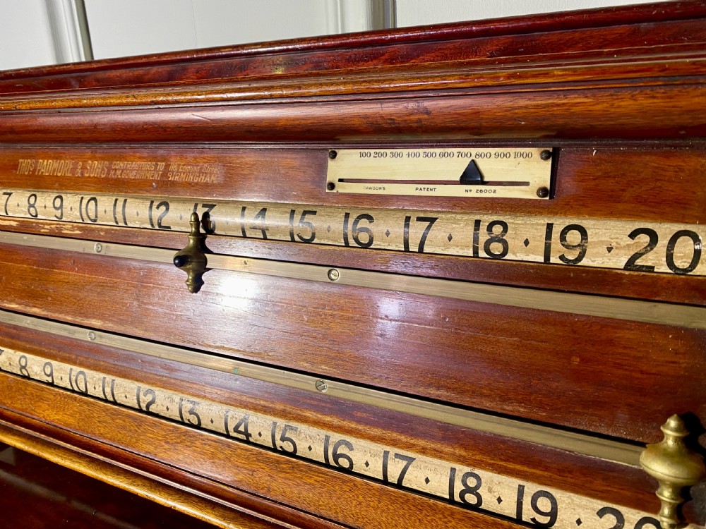 An antique Victorian mahogany and brass snooker scoreboard featuring sliding pointer markers and numbered tracks. View V
