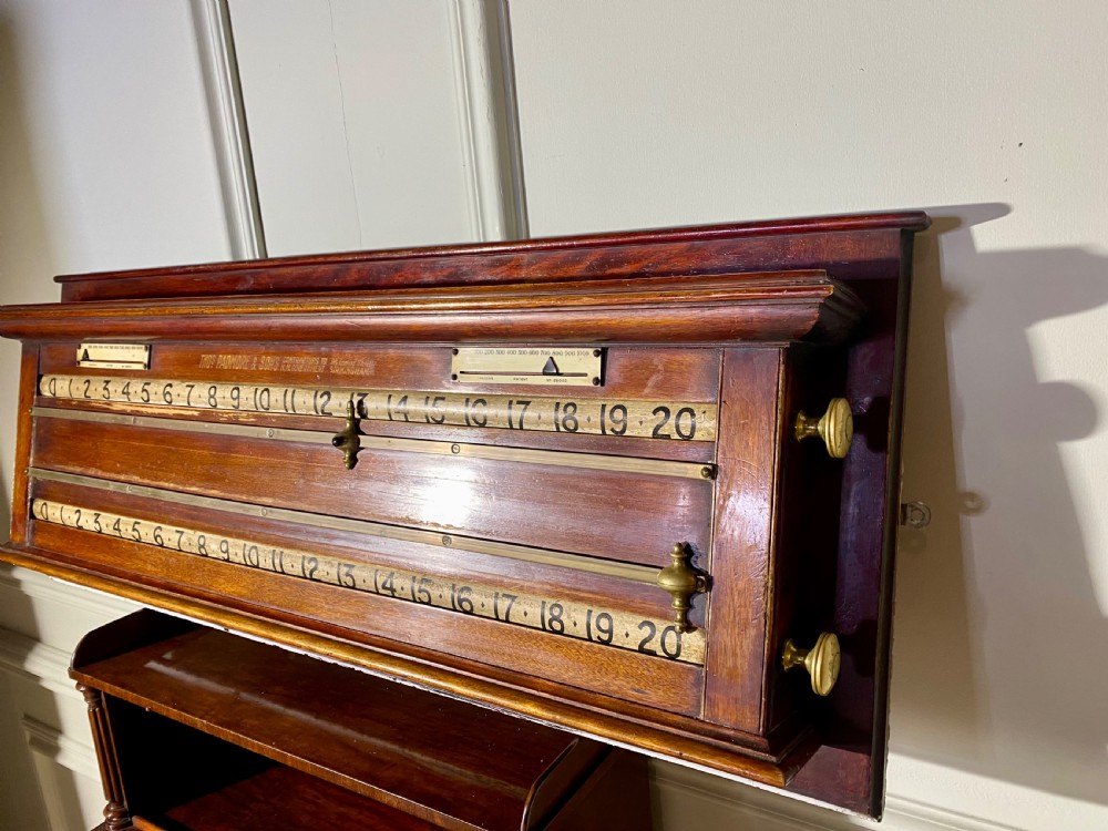 An antique Victorian mahogany and brass snooker scoreboard featuring sliding pointer markers and numbered tracks. View VI