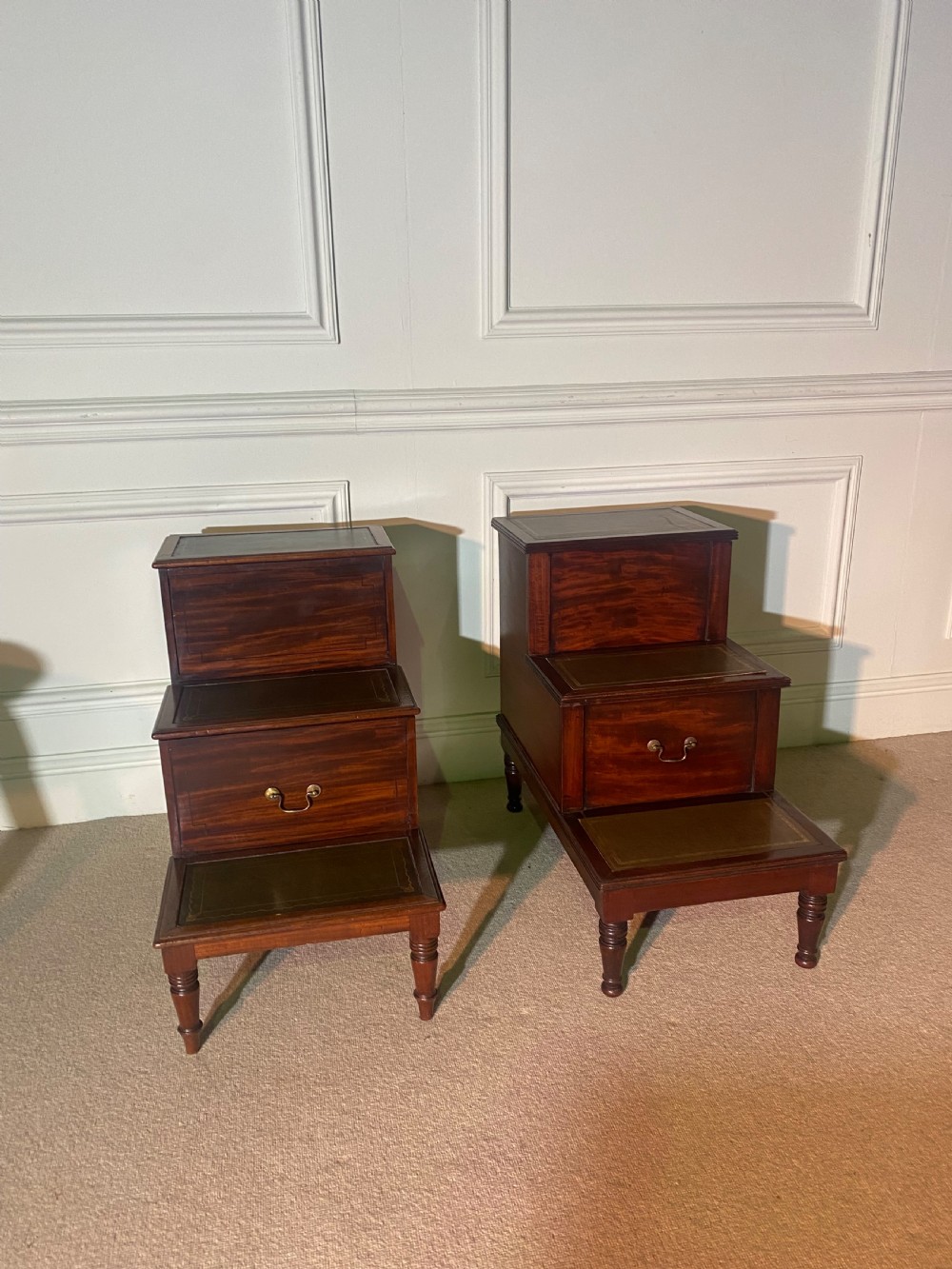A pair of Regency mahogany library steps featuring three tiered leather-inset treads and turned legs. View III