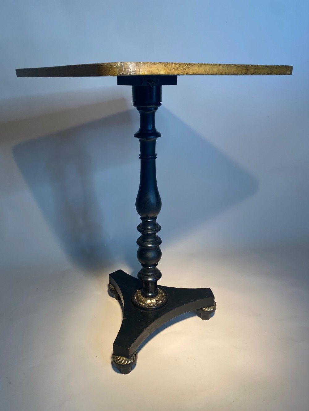 A square Regency ebonised chess table featuring detailed foliate penwork framing a central chessboard top, supported by a turned central pedestal and tripod base. View X
