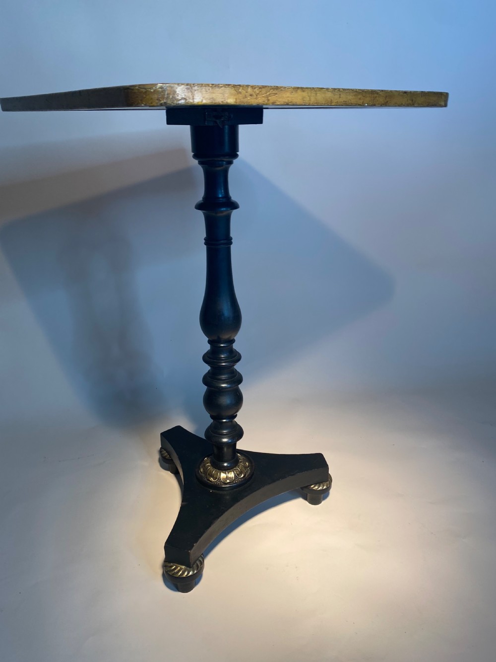 A square Regency ebonised chess table featuring detailed foliate penwork framing a central chessboard top, supported by a turned central pedestal and tripod base. View XI