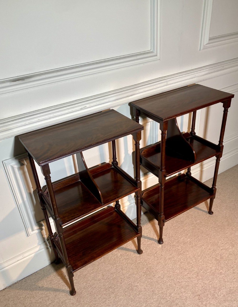 A pair of dark mahogany three-tier open bedside tables with turned supports and pad feet. View IV