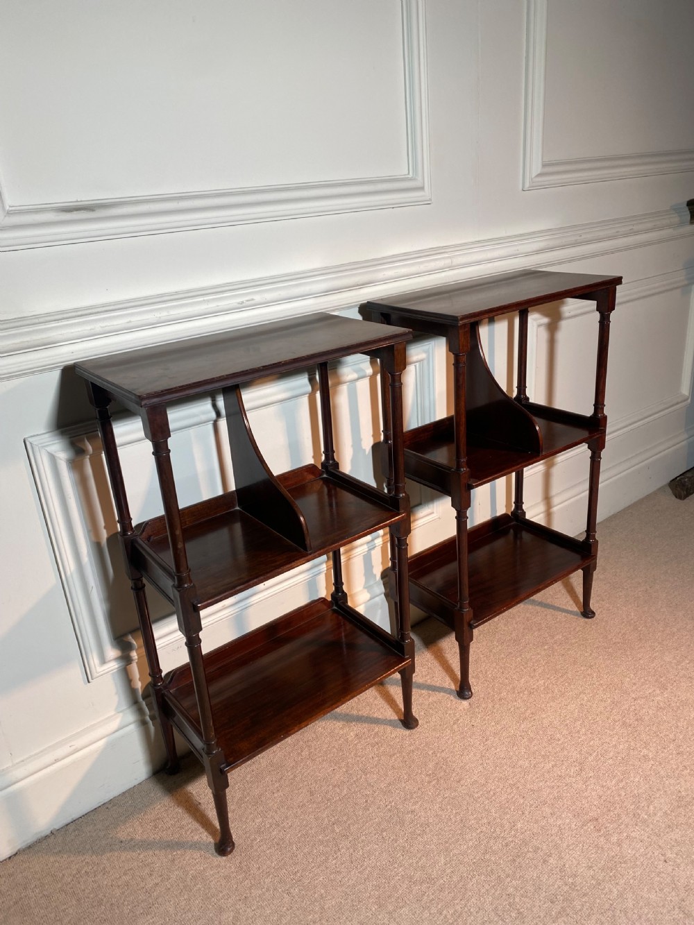 A pair of dark mahogany three-tier open bedside tables with turned supports and pad feet. View VI