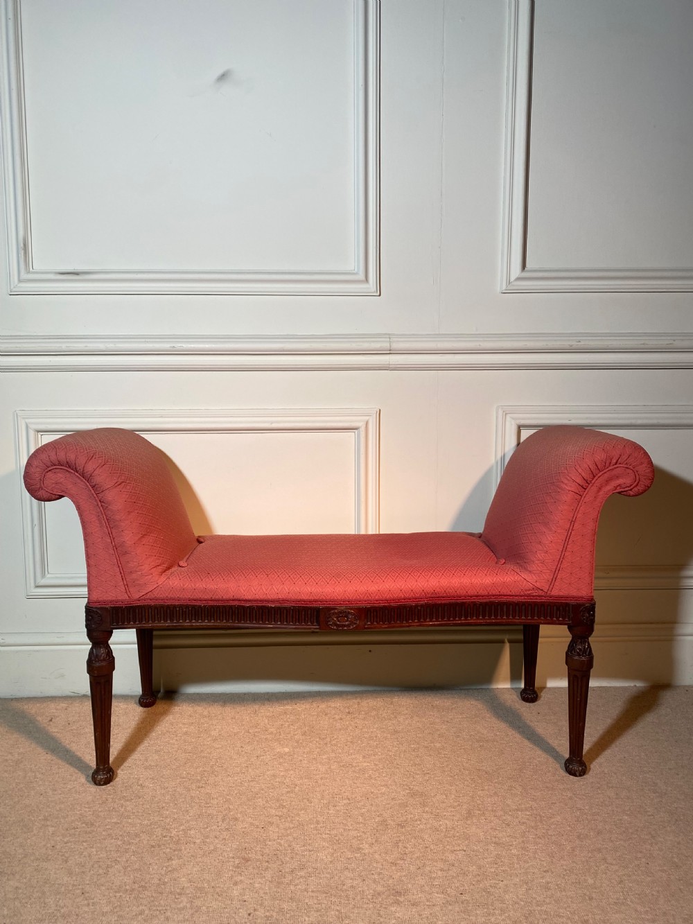 A Hepplewhite style window seat featuring rose pink patterned fabric upholstery, twin scrolled ends, and carved mahogany fluted legs. View II