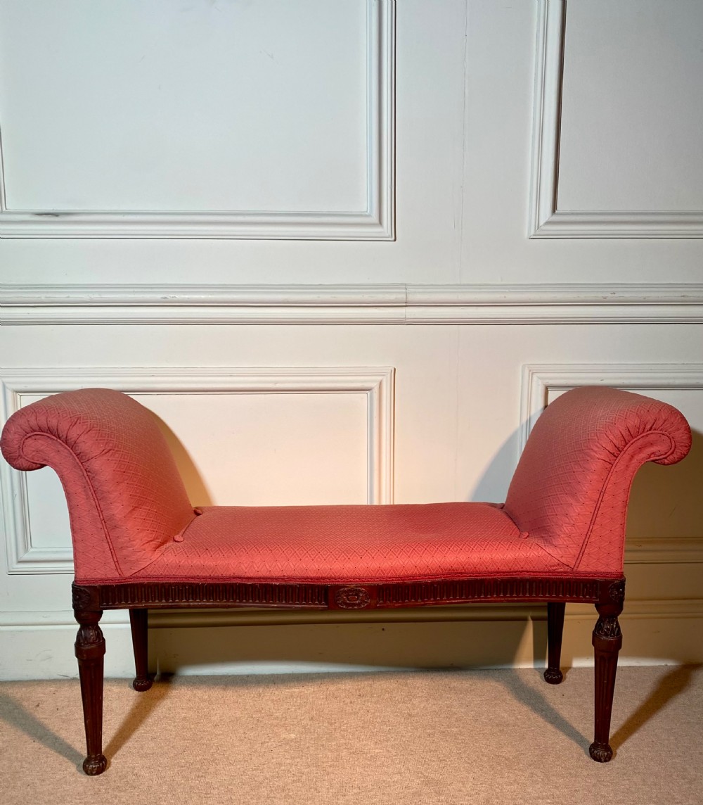 A Hepplewhite style window seat featuring rose pink patterned fabric upholstery, twin scrolled ends, and carved mahogany fluted legs. View VI