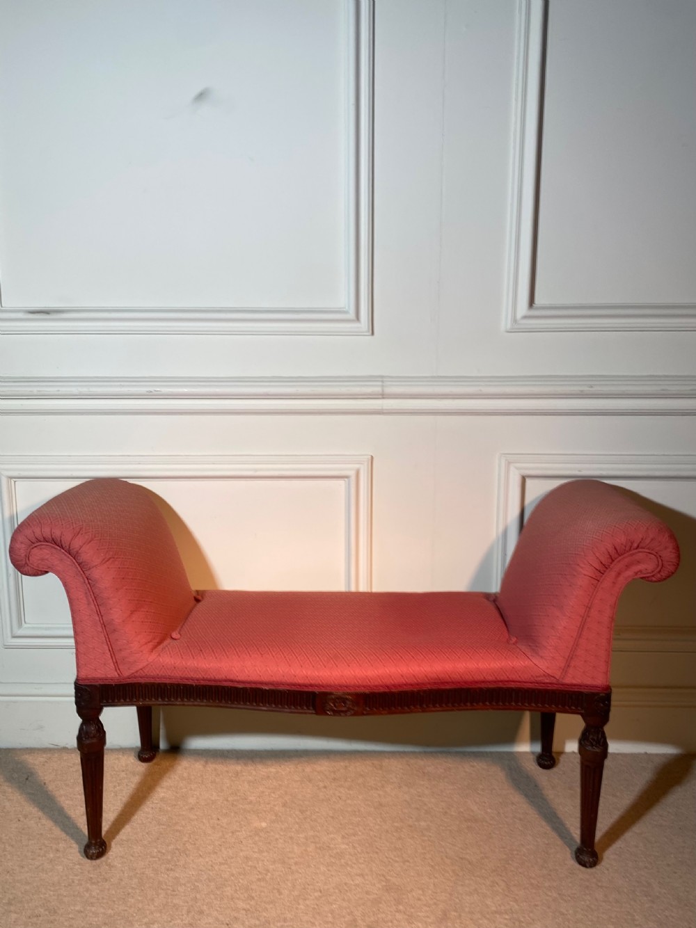 A Hepplewhite style window seat featuring rose pink patterned fabric upholstery, twin scrolled ends, and carved mahogany fluted legs. View VII