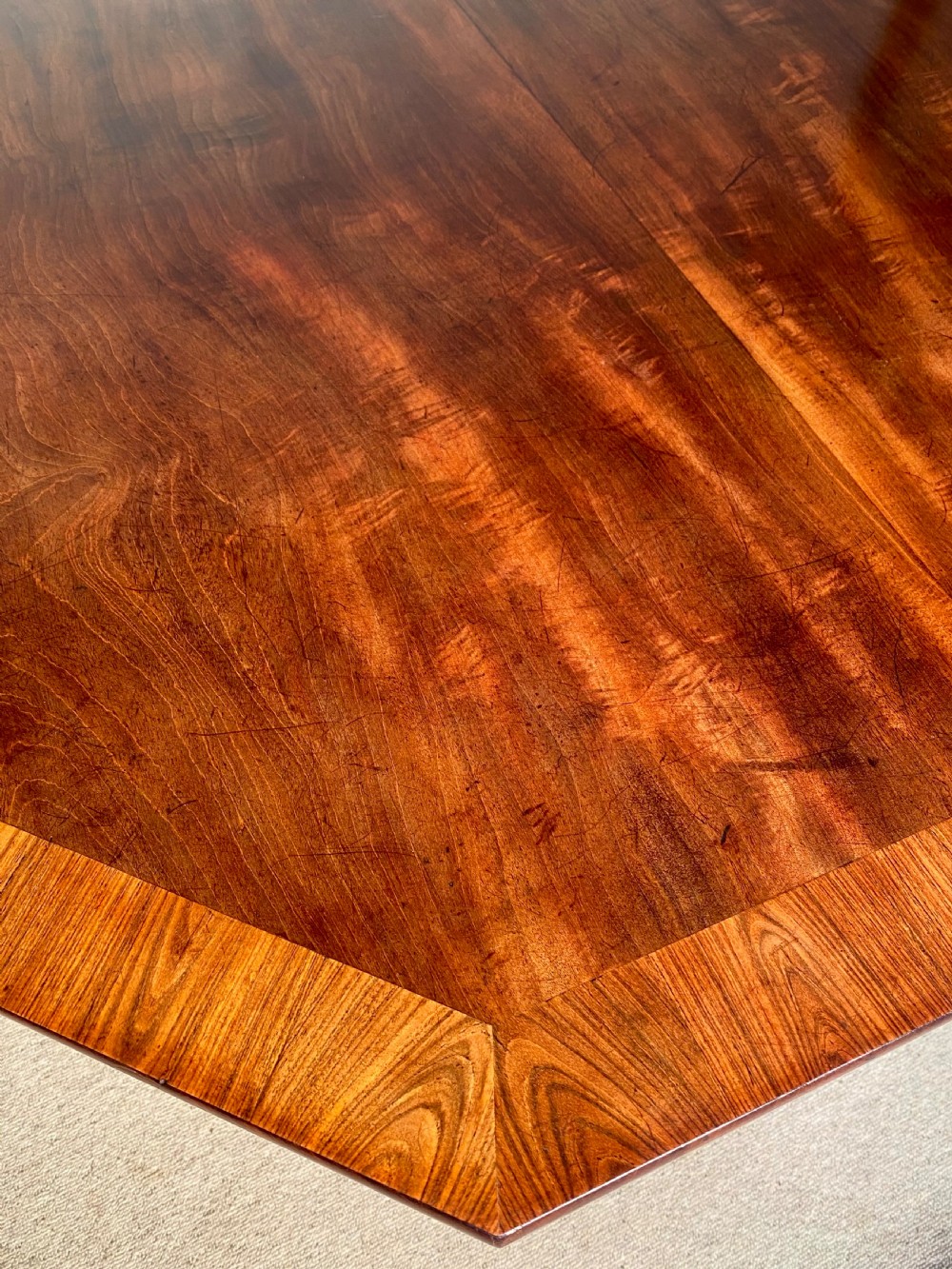 A Regency mahogany hexagonal centre table with a faceted pedestal support and carved lion paw feet. View II