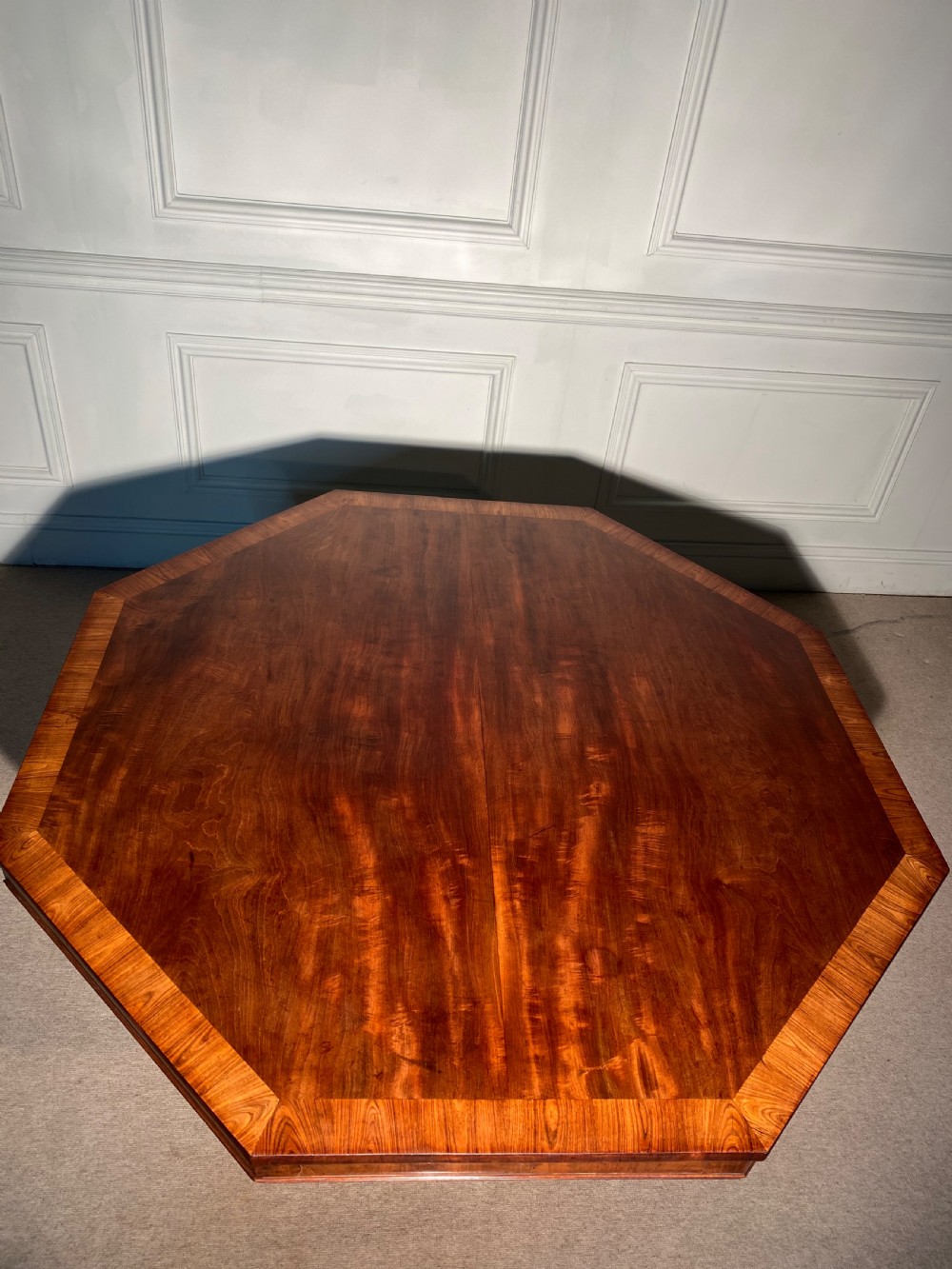 A Regency mahogany hexagonal centre table with a faceted pedestal support and carved lion paw feet. View VII