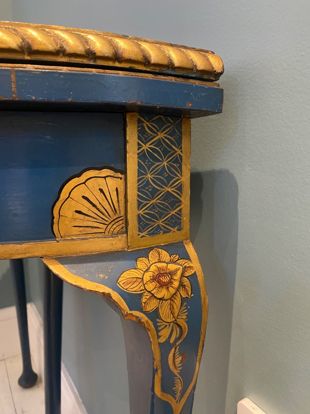 A dark blue lacquered demi-lune card table decorated with gilded Chinoiserie scenes, standing on slender legs with carved shell details. View VI