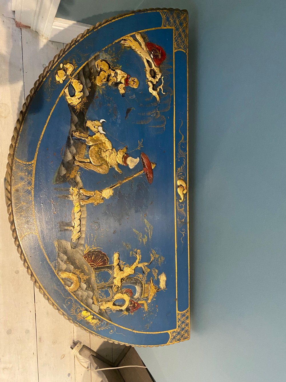 A dark blue lacquered demi-lune card table decorated with gilded Chinoiserie scenes, standing on slender legs with carved shell details. View VII