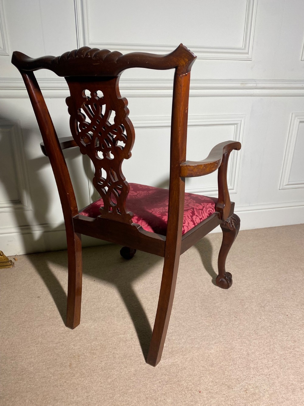 A Chippendale style mahogany carver armchair featuring an intricately carved pierced splat back, red patterned damask upholstery, and cabriole legs with ball and claw feet. View VII