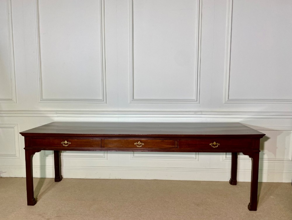 A long Georgian mahogany serving table featuring three frieze drawers with brass swan-neck handles and straight square legs. View III