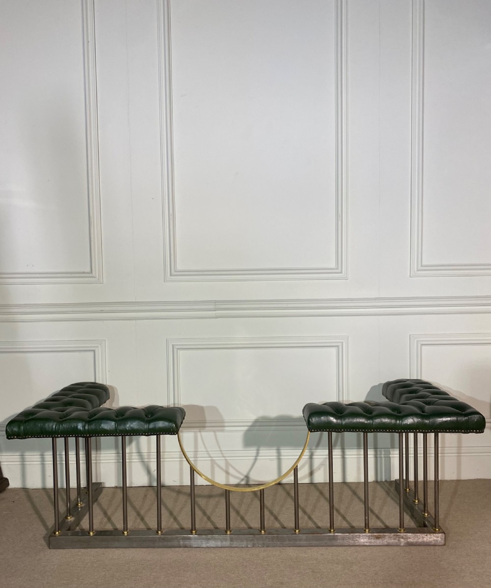 A metal fireplace club fender with vertical steel uprights, brass accents, a central curved dip, and two corner seats upholstered in button-tufted dark green leather with brass studding. View IX