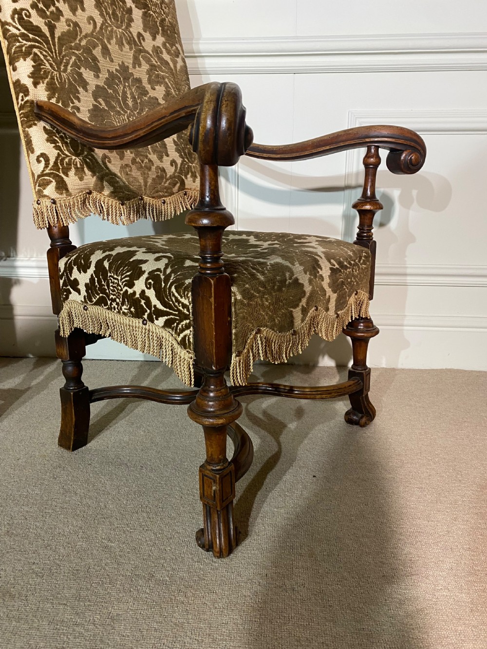 A pair of high-back Carolean style armchairs upholstered in patterned brown velvet with fringe trim and carved timber frames. View VI