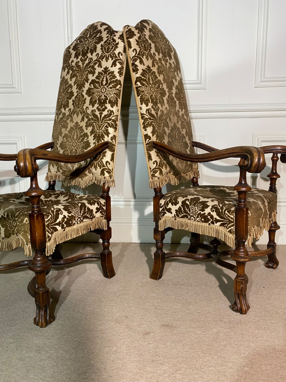 A pair of high-back Carolean style armchairs upholstered in patterned brown velvet with fringe trim and carved timber frames. View VIII