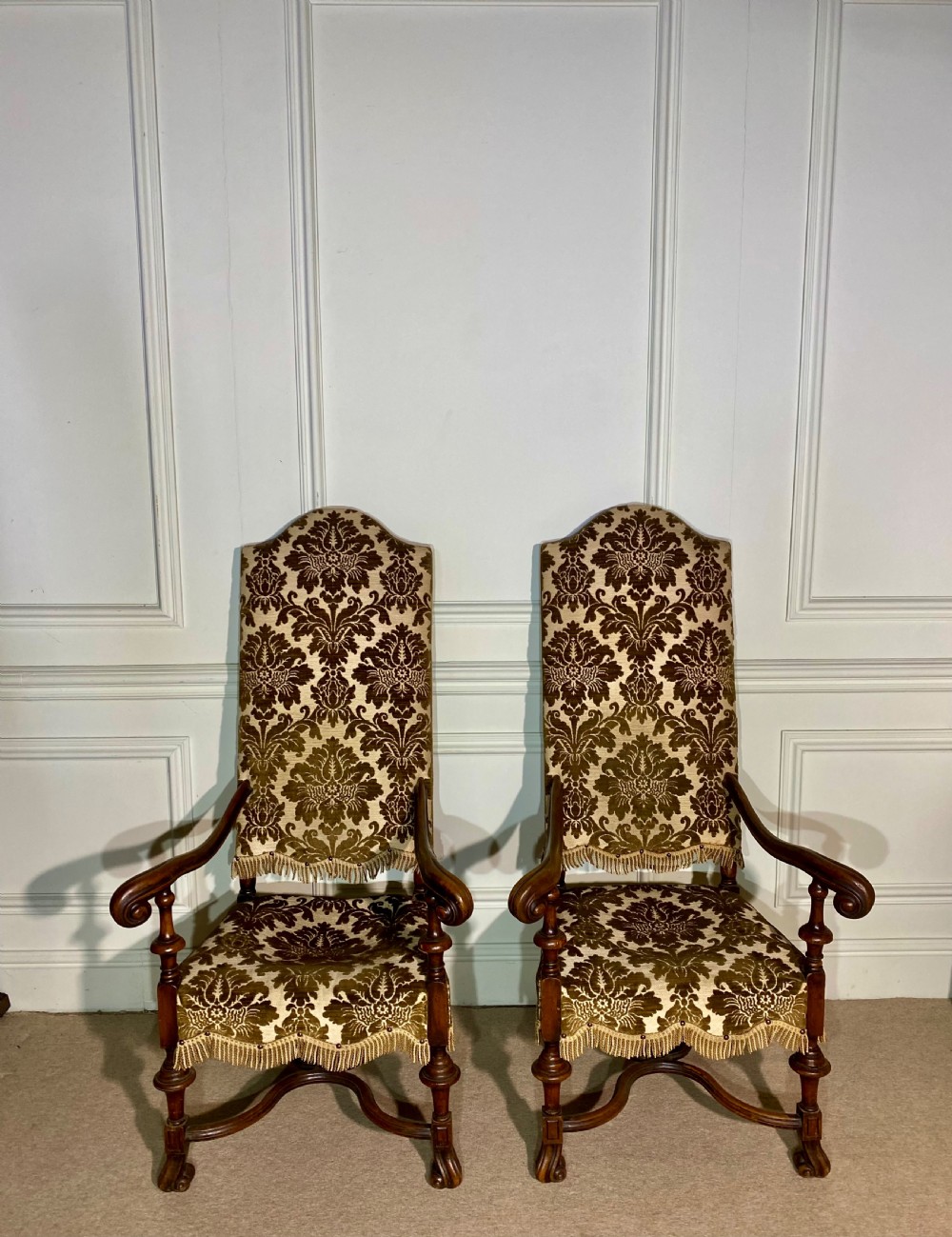 A pair of high-back Carolean style armchairs upholstered in patterned brown velvet with fringe trim and carved timber frames. View XI