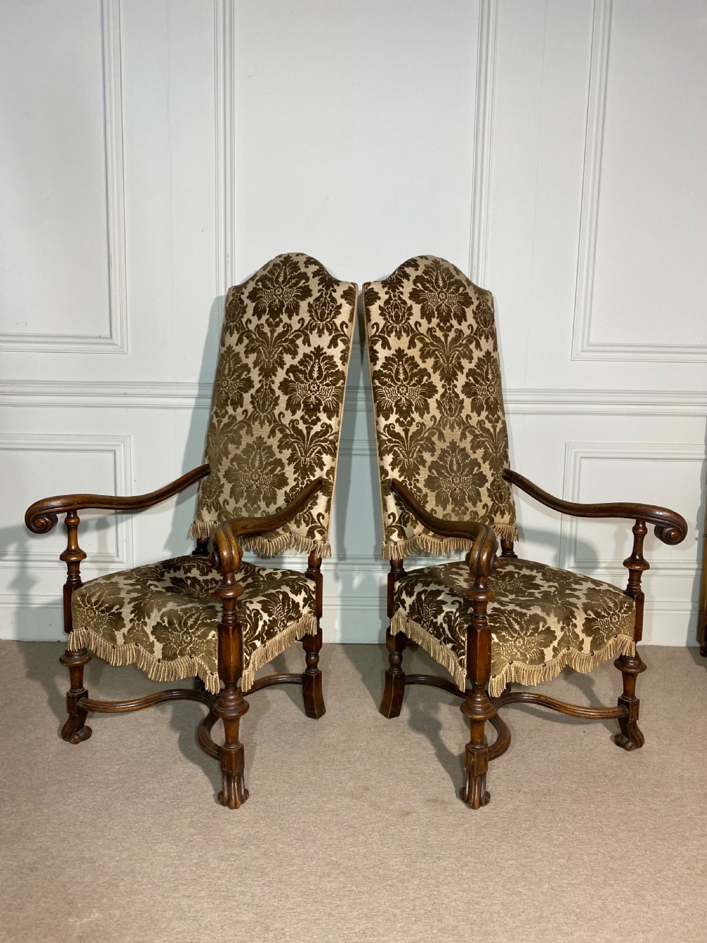 A pair of high-back Carolean style armchairs upholstered in patterned brown velvet with fringe trim and carved timber frames. View XII