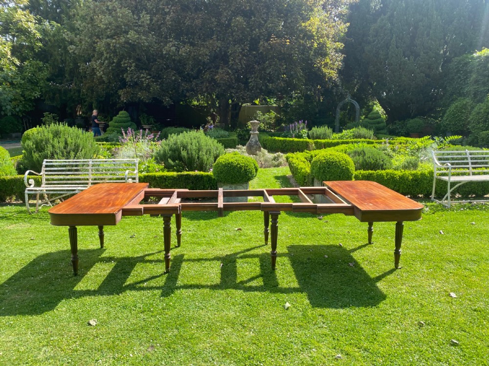 An early nineteenth century Regency mahogany extending dining table featuring reeded turned legs on brass castors. View VII