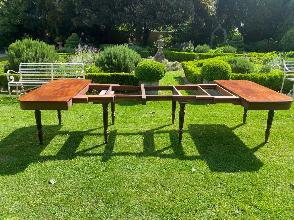 An early nineteenth century Regency mahogany extending dining table featuring reeded turned legs on brass castors. View VIII