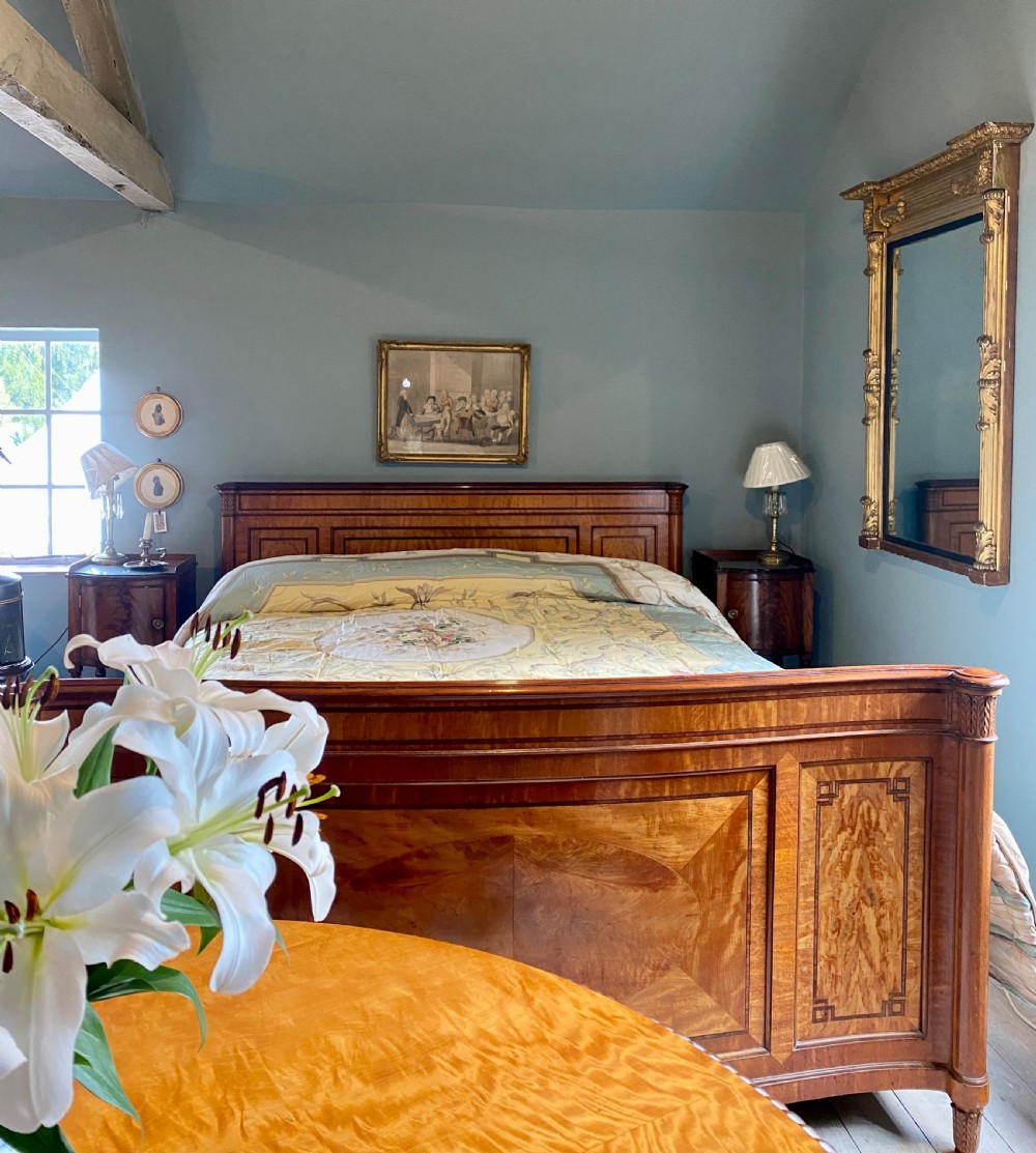 A nineteenth-century king-size satinwood bed frame featuring crossbanded panelling, an oval central veneer inlay on the footboard, and turned corner columns. View II