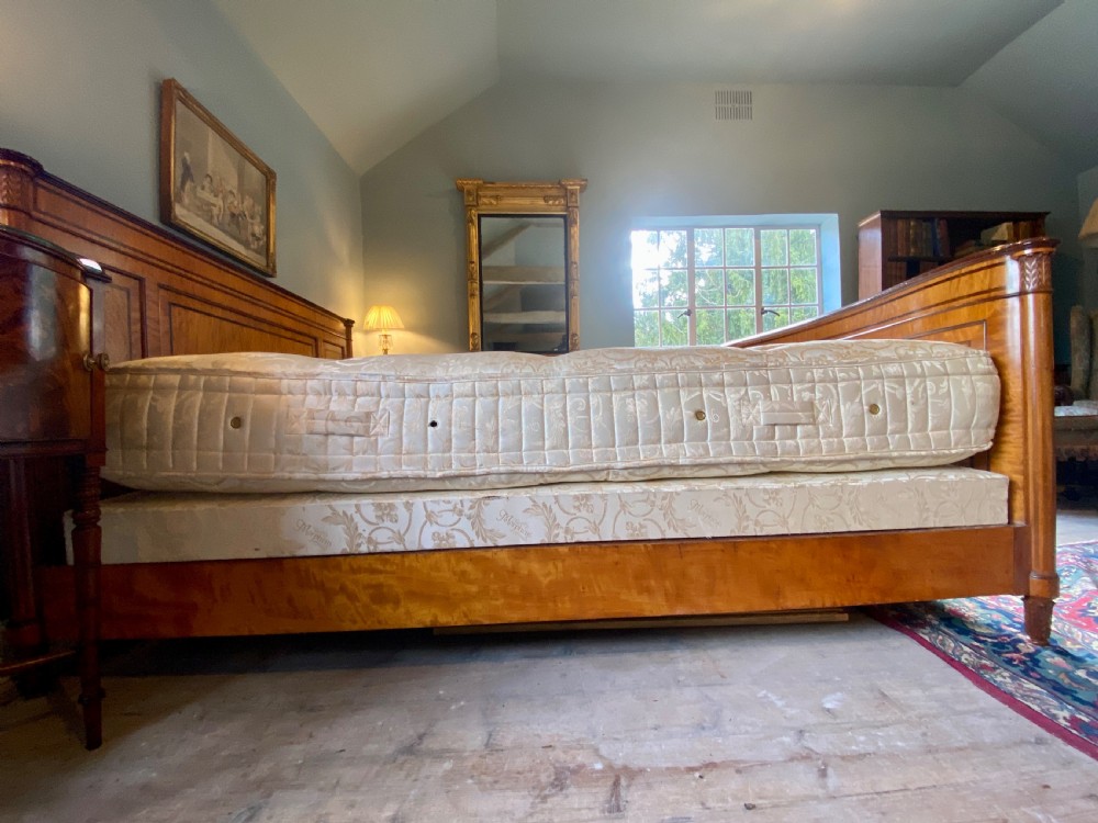 A nineteenth-century king-size satinwood bed frame featuring crossbanded panelling, an oval central veneer inlay on the footboard, and turned corner columns. View III