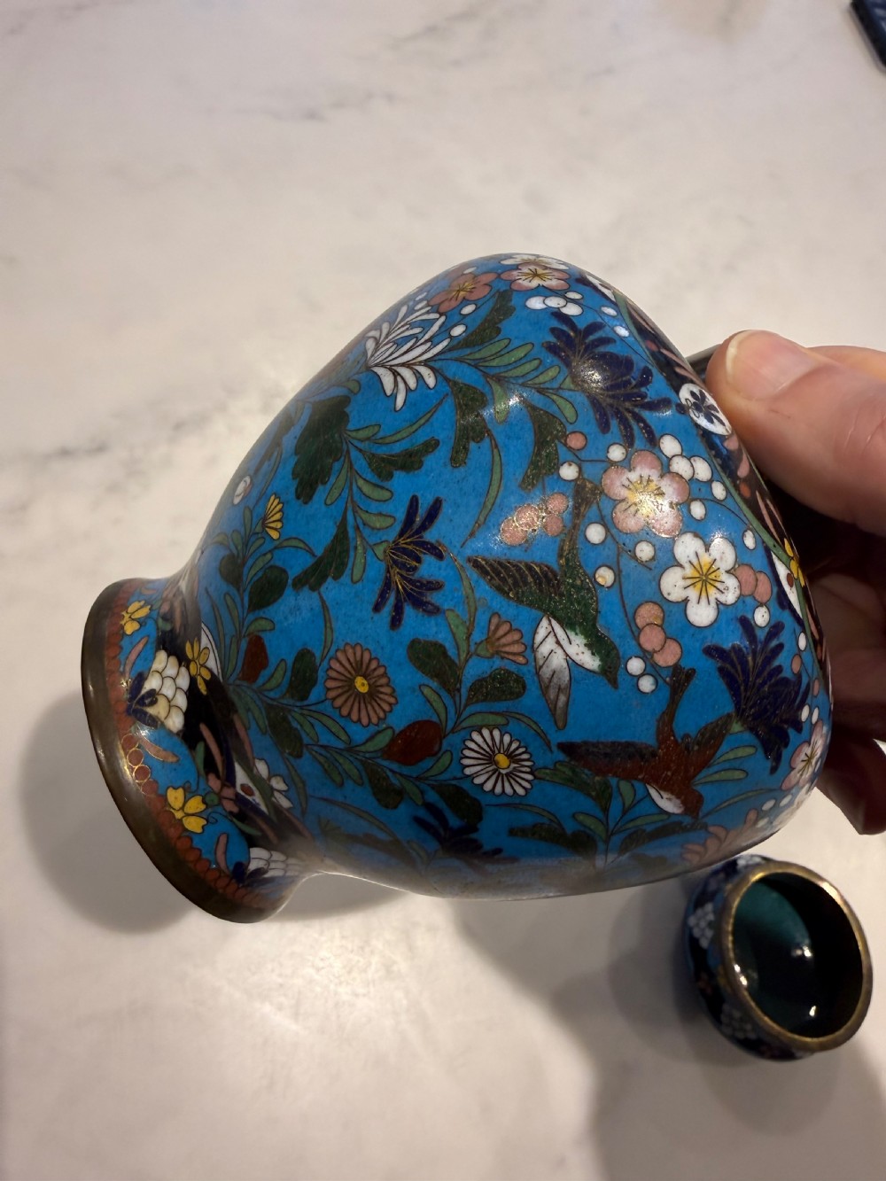 A pair of bulbous Japanese cloisonne ginger jars with lids, featuring intricate floral and bird motifs on a vibrant turquoise blue ground. View VII