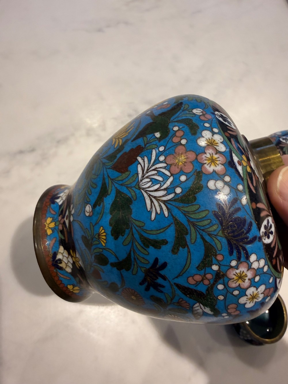 A pair of bulbous Japanese cloisonne ginger jars with lids, featuring intricate floral and bird motifs on a vibrant turquoise blue ground. View VIII