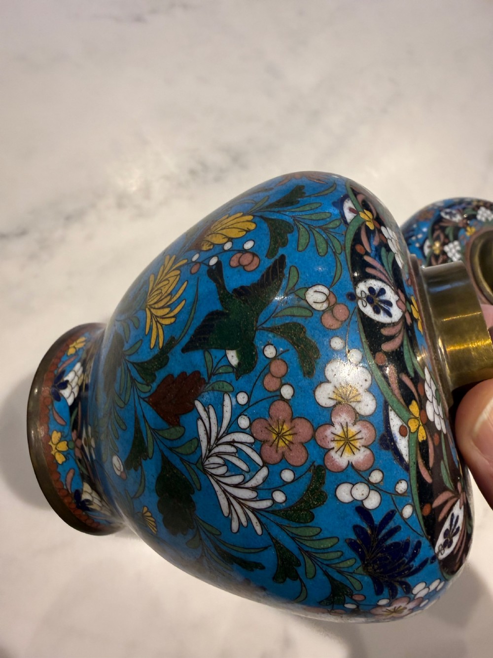 A pair of bulbous Japanese cloisonne ginger jars with lids, featuring intricate floral and bird motifs on a vibrant turquoise blue ground. View IX