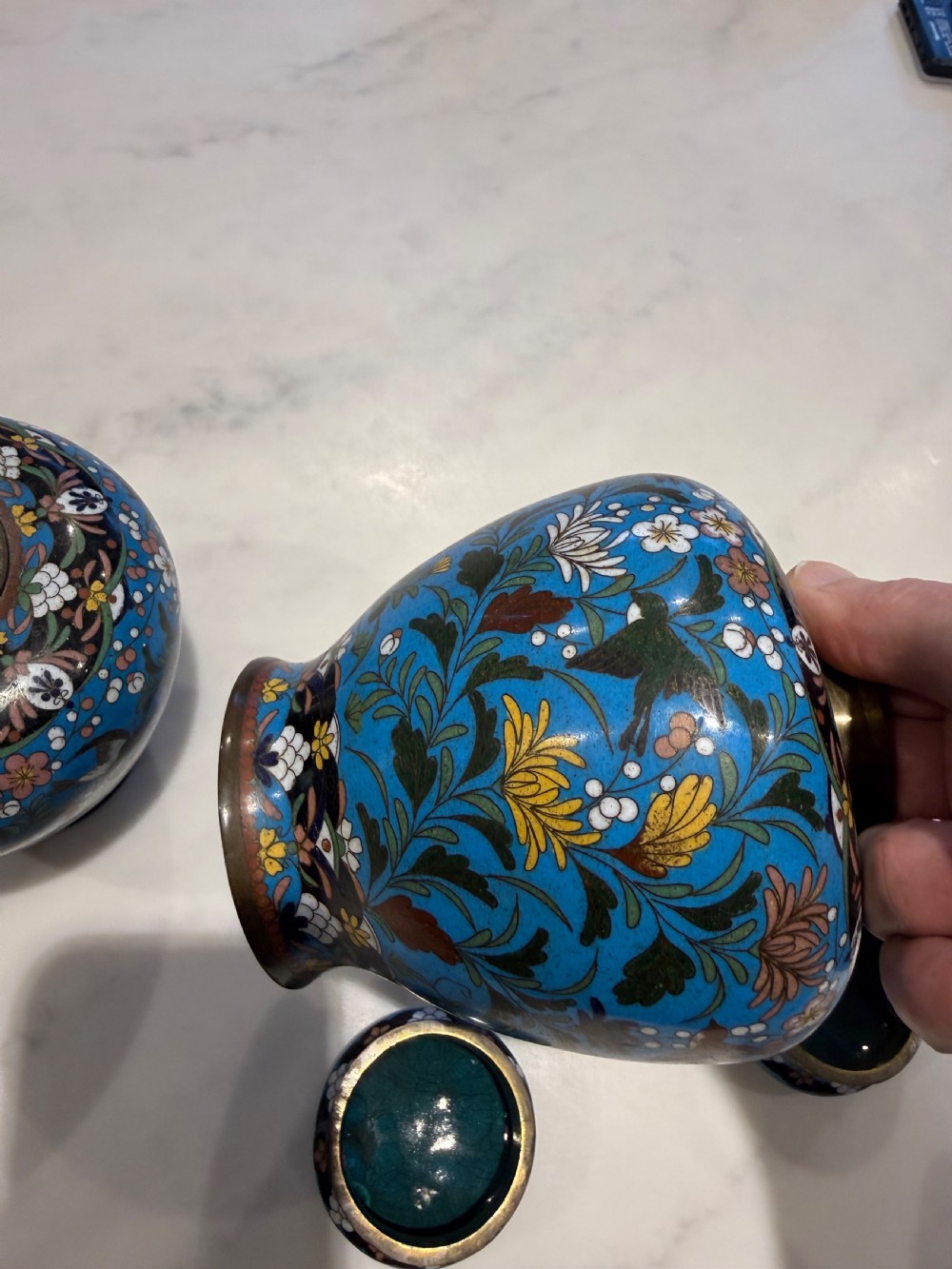 A pair of bulbous Japanese cloisonne ginger jars with lids, featuring intricate floral and bird motifs on a vibrant turquoise blue ground. View XI