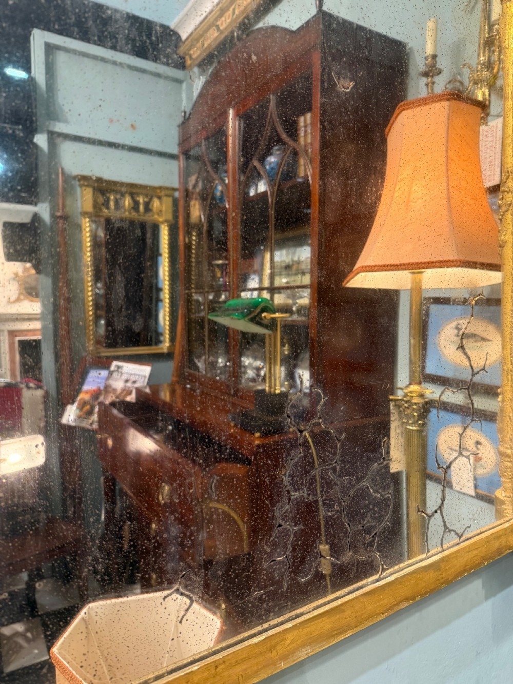 A large rectangular Regency giltwood overmantel mirror featuring architectural fluted pilasters, corner rosettes, and floral moulding along the top frame. View IV