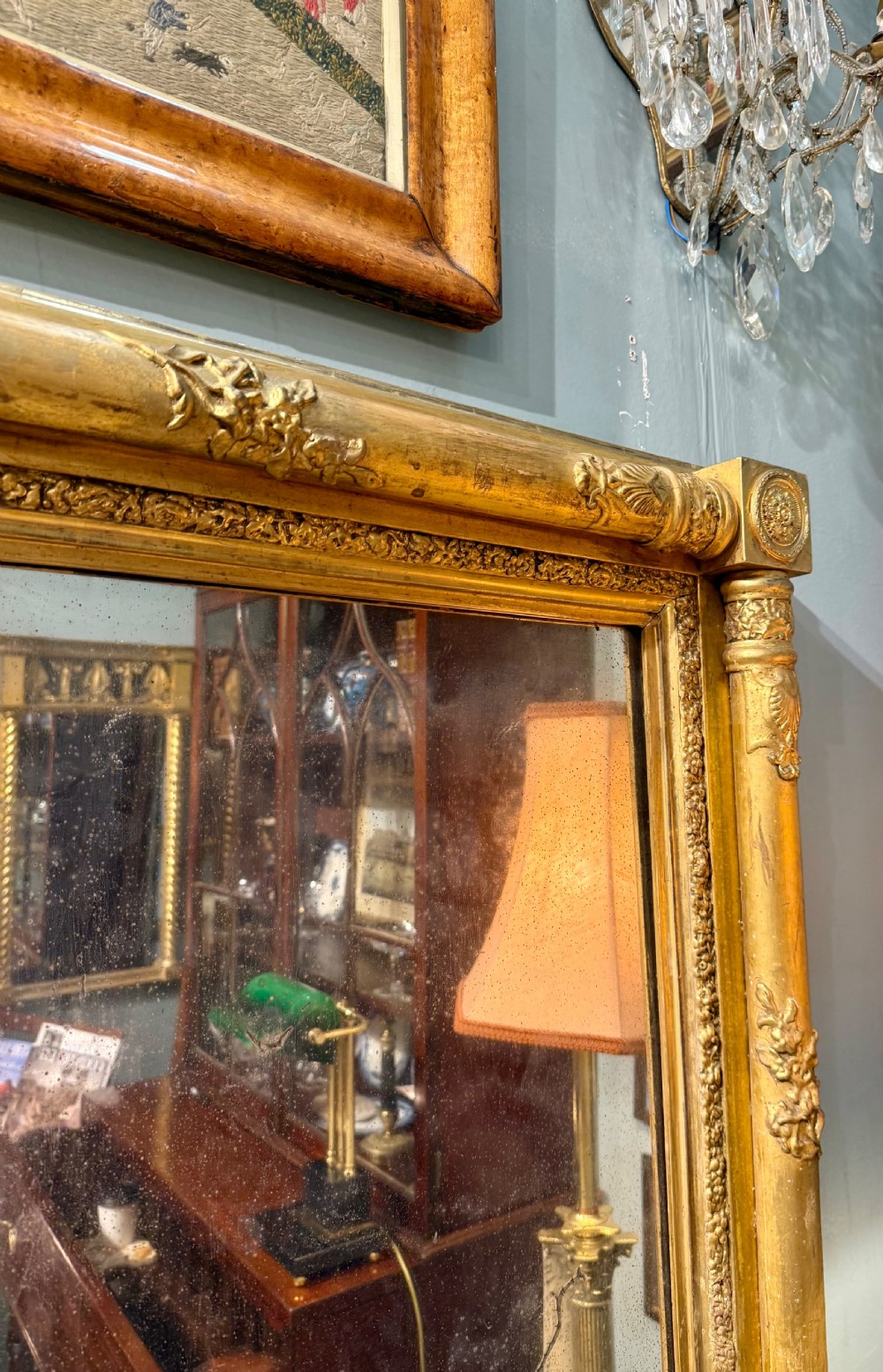 A large rectangular Regency giltwood overmantel mirror featuring architectural fluted pilasters, corner rosettes, and floral moulding along the top frame. View VII