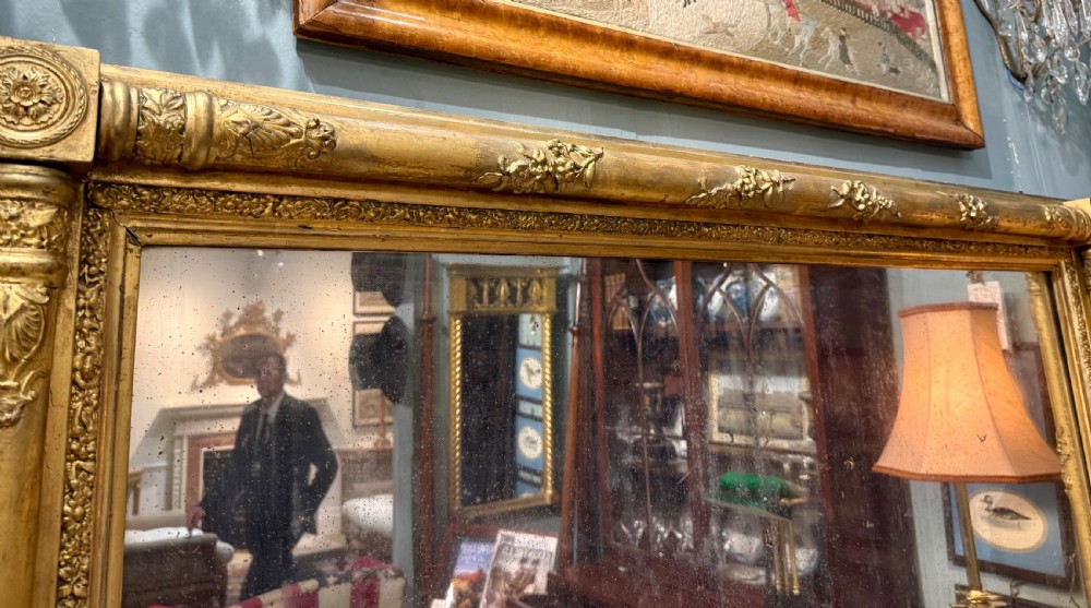 A large rectangular Regency giltwood overmantel mirror featuring architectural fluted pilasters, corner rosettes, and floral moulding along the top frame. View VIII