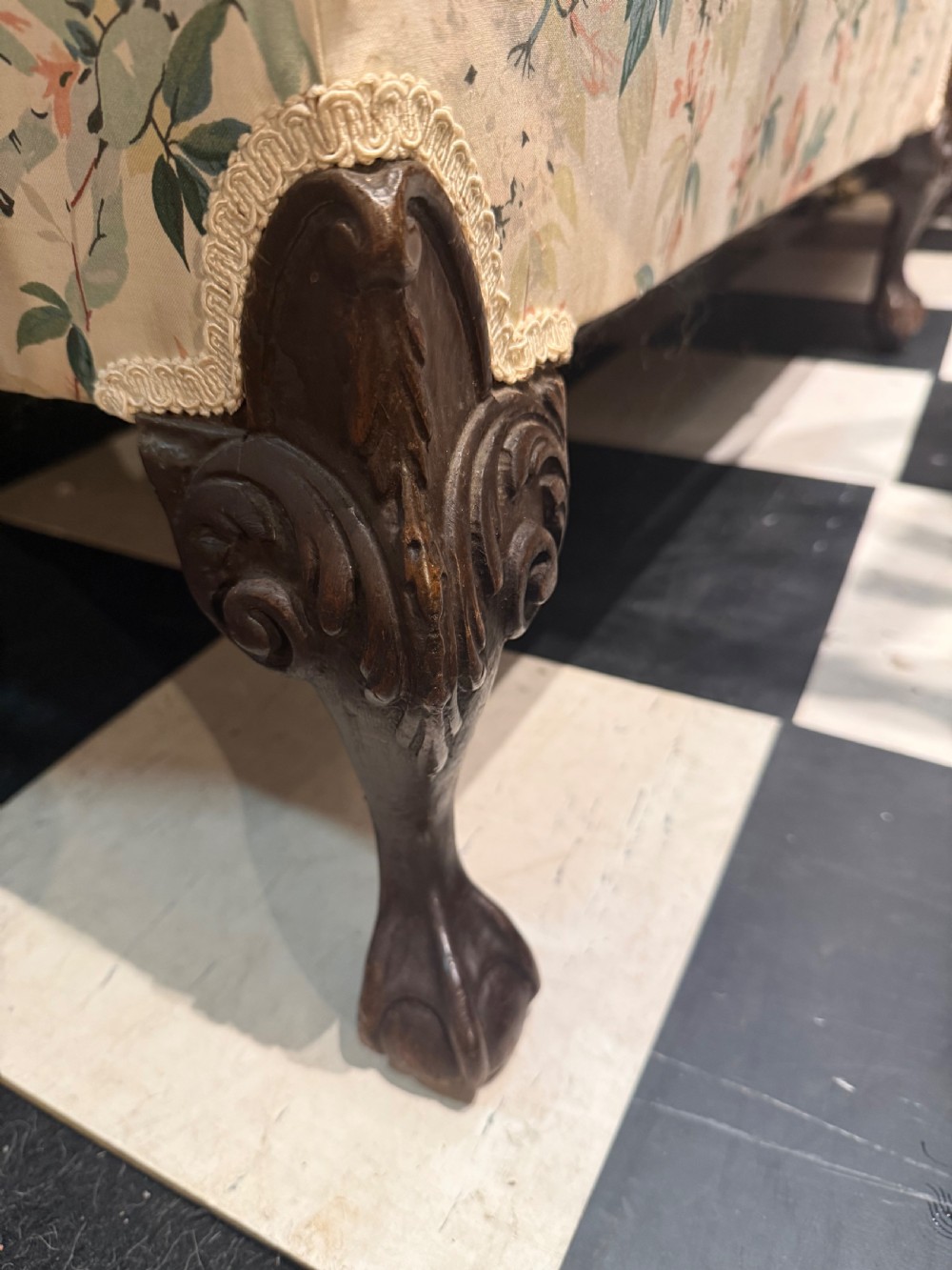 A nineteenth-century Chippendale style camel back sofa with floral chintz upholstery and carved mahogany legs. View IV