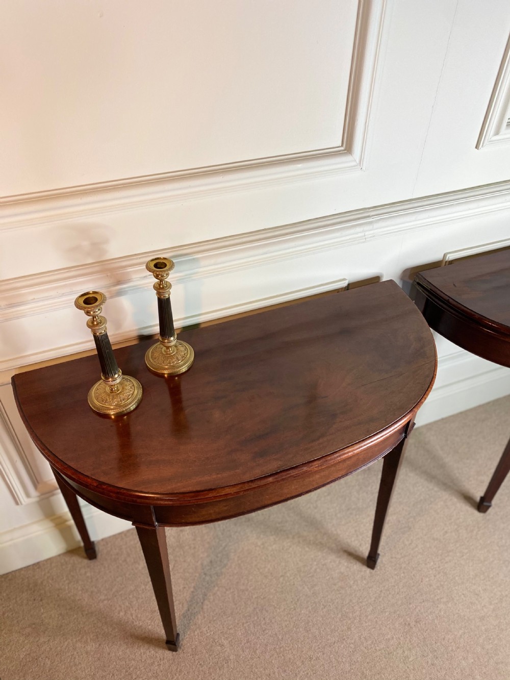A pair of late eighteenth-century Georgian mahogany demilune card tables with fold-over tops and square tapered legs. View V