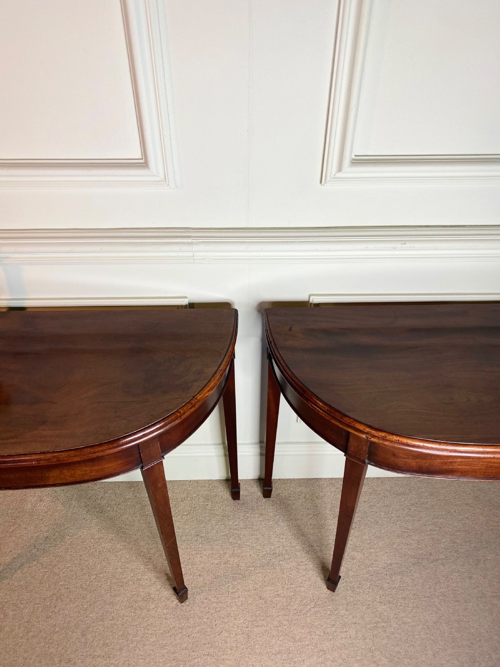 A pair of late eighteenth-century Georgian mahogany demilune card tables with fold-over tops and square tapered legs. View VI