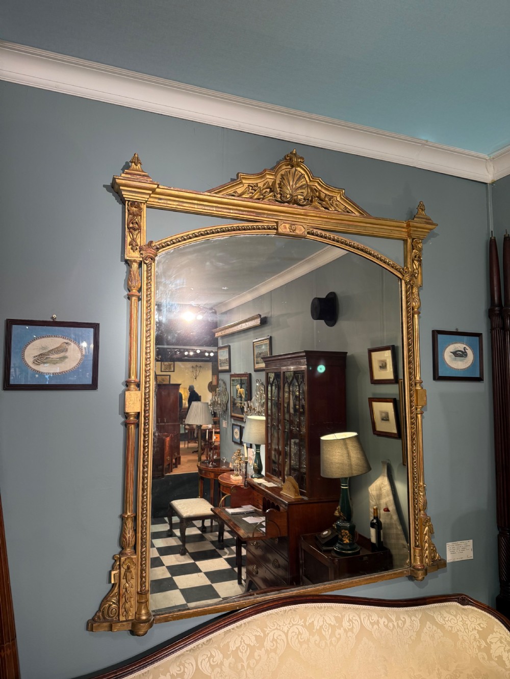 A 19th-century giltwood overmantel mirror featuring an arched top, detailed shell cresting, and carved side pilasters. View II