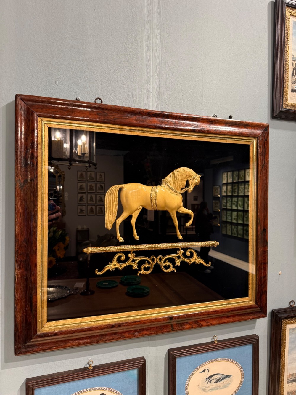 A 19th-century gilt bronze relief sculpture of a horse mounted on a dark background within a rosewood frame with gold slip. View III
