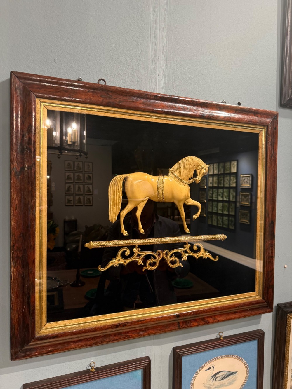 A 19th-century gilt bronze relief sculpture of a horse mounted on a dark background within a rosewood frame with gold slip. View IV