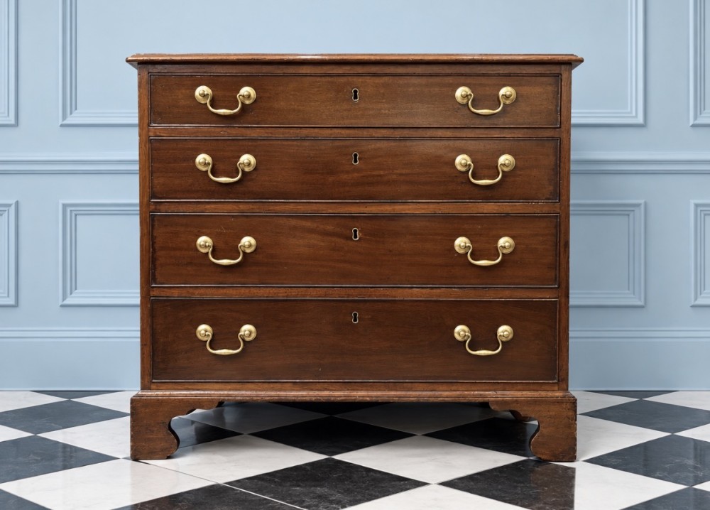 An 18th-century George III mahogany chest of drawers with four graduated drawers, brass swan-neck handles, keyhole escutcheons, and bracket feet.
