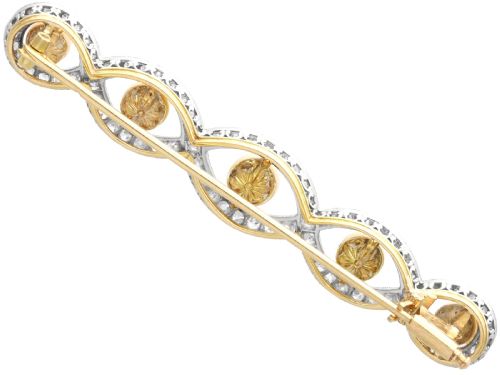 fig 4. An Art Deco gold bar brooch featuring five natural pearls framed within a diamond-set intertwined ribbon setting.
