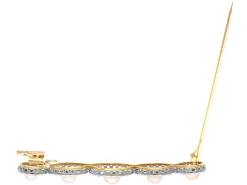 fig 5. An Art Deco gold bar brooch featuring five natural pearls framed within a diamond-set intertwined ribbon setting.