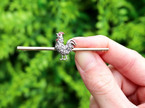fig 1. An antique 14ct yellow gold bar brooch adorned with a silver-set diamond cockerel motif featuring a ruby eye and red enamelled details.