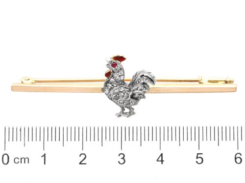 fig 6. An antique 14ct yellow gold bar brooch adorned with a silver-set diamond cockerel motif featuring a ruby eye and red enamelled details.