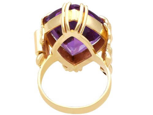 fig 6. A vintage 14ct yellow gold dress ring featuring a large faceted purple amethyst with textured claw settings and small diamond accents.