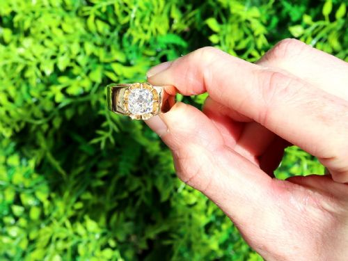 fig 1. An antique 18ct yellow gold solitaire ring featuring a broad band and a cushion cut diamond set in a scalloped collet.