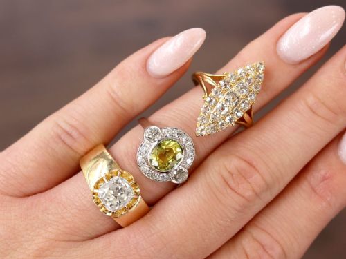 fig 3. An antique 18ct yellow gold solitaire ring featuring a broad band and a cushion cut diamond set in a scalloped collet.